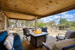 Lower-covered wooden patio with a firebox